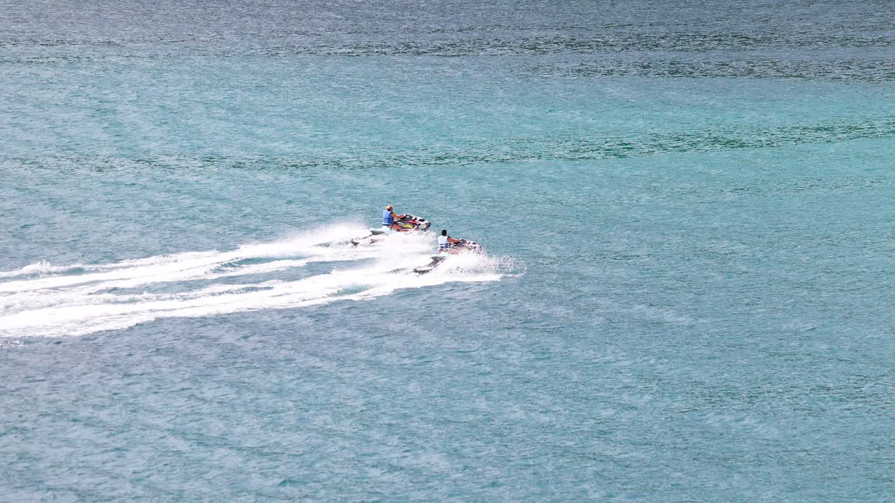 un emocionante paseo en jet ski a través de las aguas turquesas de phuket, capturando la velocidad y la emoción bajo la brillante luz del día