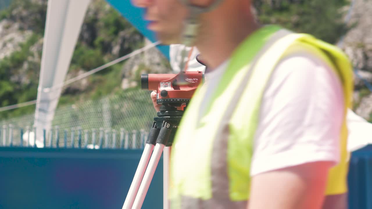 Construction Surveyor Using Level on Bridge Construction Site