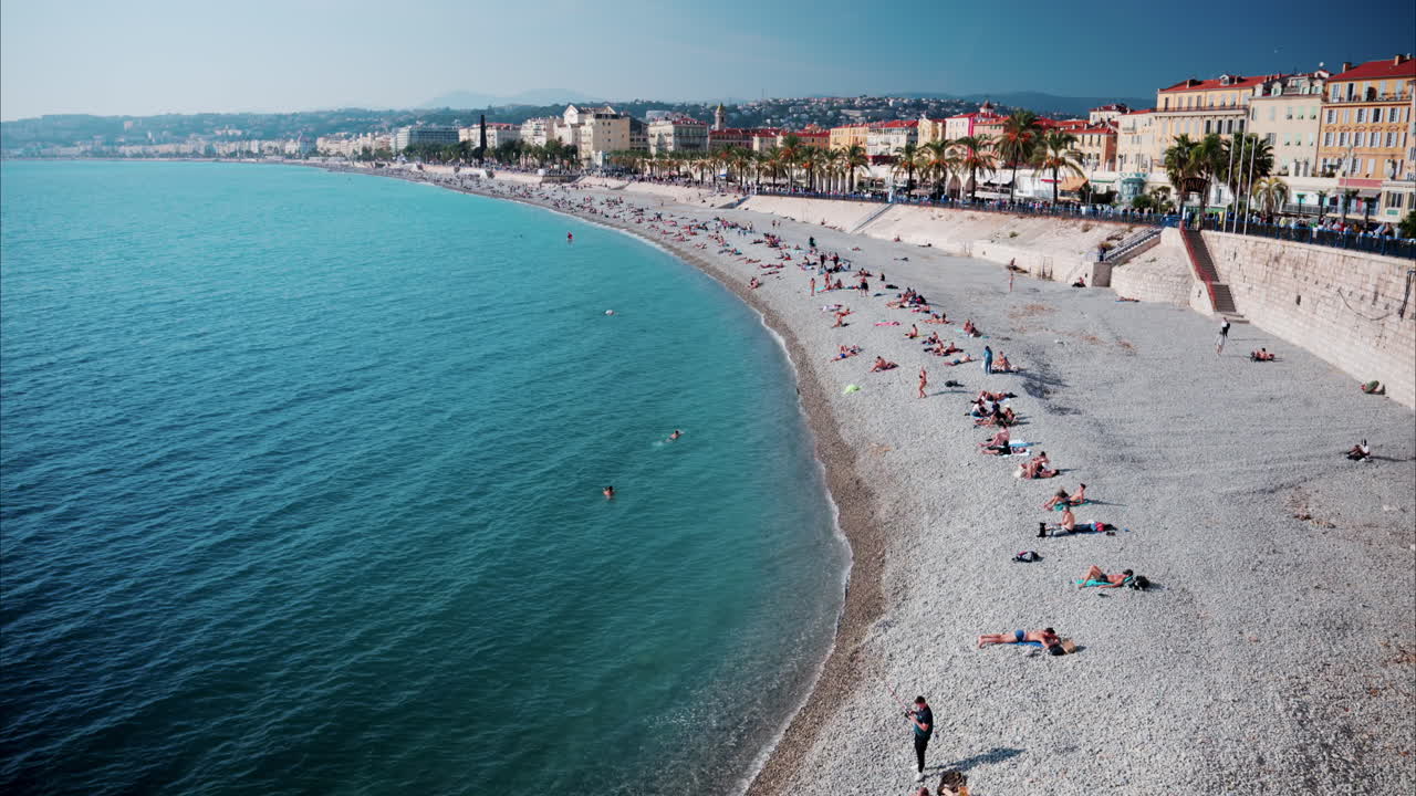 View of the coastline of Nice, France with people at the beach in the French Riviera