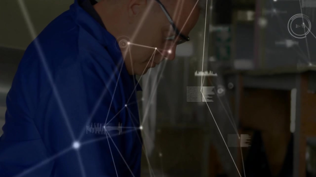 Maintenance tech lifting tablet from red cart in workshop activating diagnostic data overlay