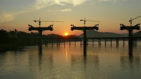 bridge construction sunset over river