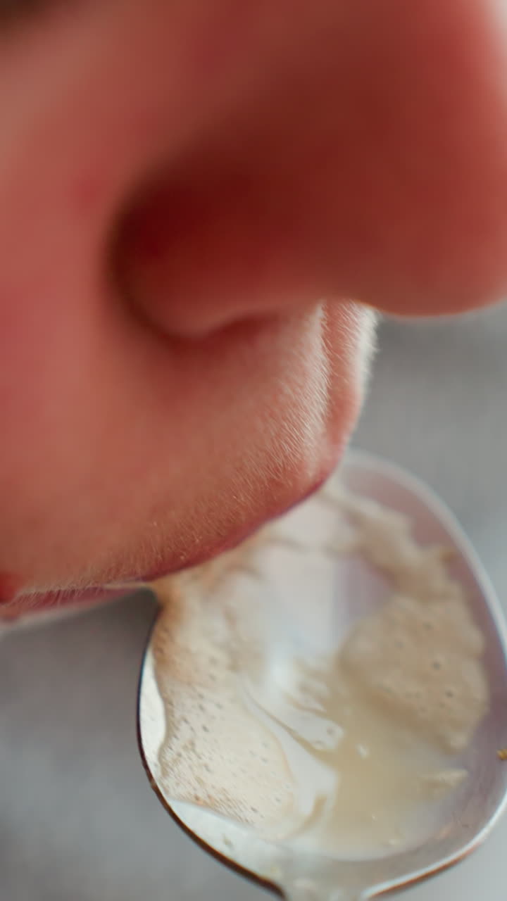 taza cuchara espuma primer plano caucásico degustación, muestreo de espuma estilo barista de taza turquesa, la cuchara levanta la crema para un pequeño sorbo, vapor cálido y ambiente de mostrador acogedor, se enfatiza la espuma táctil y el aroma