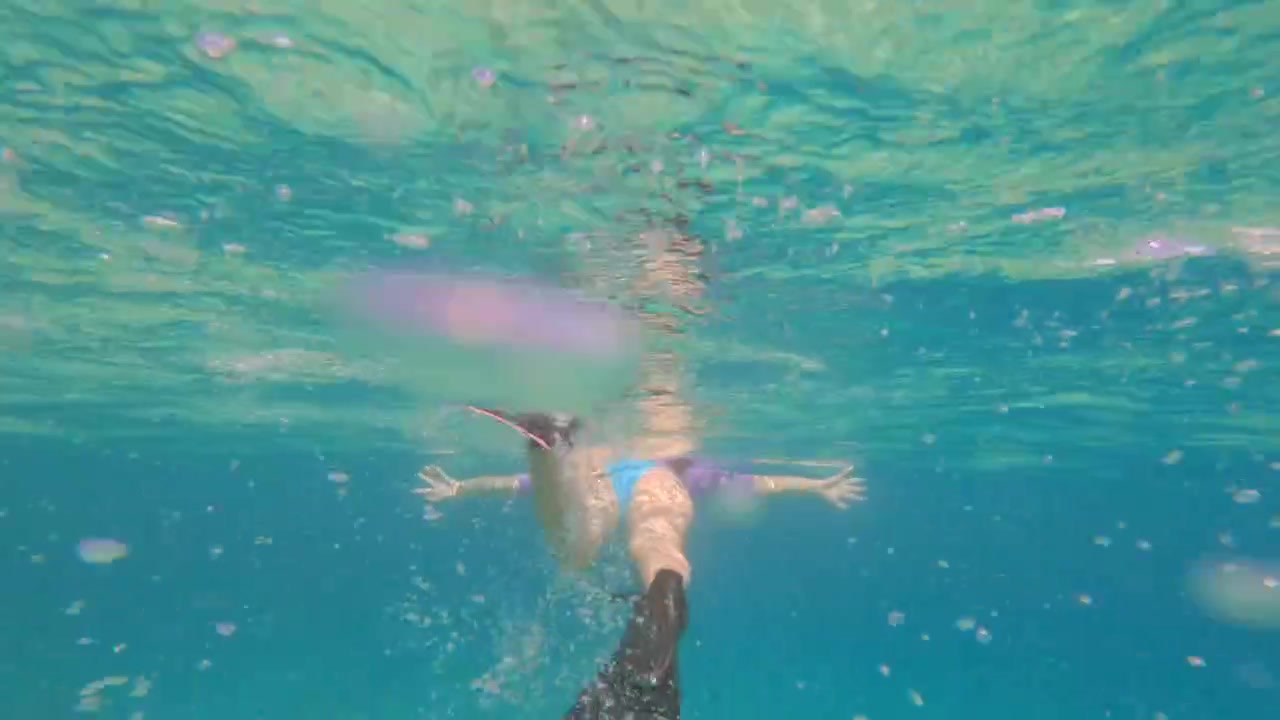 Donna che nuota con le pinne nell'oceano trasparente e turchese a Sunset Beach, Mahe, Seychelles 60fps