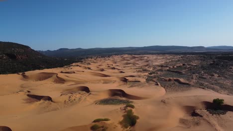 drone shot panning across pink coral sand dunes state park in a generic desert landscape