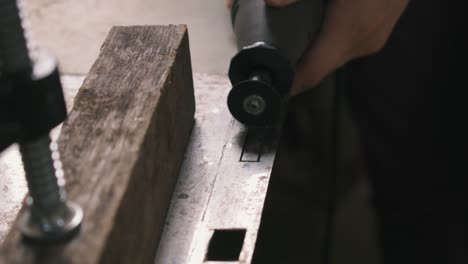 woman hands cutting a door lock sheet piece of metal with a small die grinder