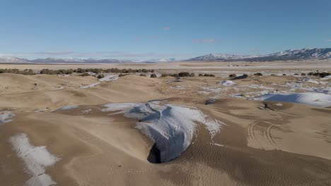 aerial flyover snowy little sahara desert with sand dunes in winter