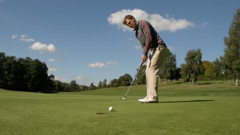 a golfer sinks the putt and celebrates.