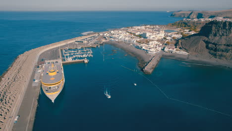 vista aérea en un círculo sobre la roca de nieves, el ferry atracado y el puerto de las nieves