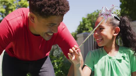 Happy-biracial-father-and-daughter-playing-together-in-garden