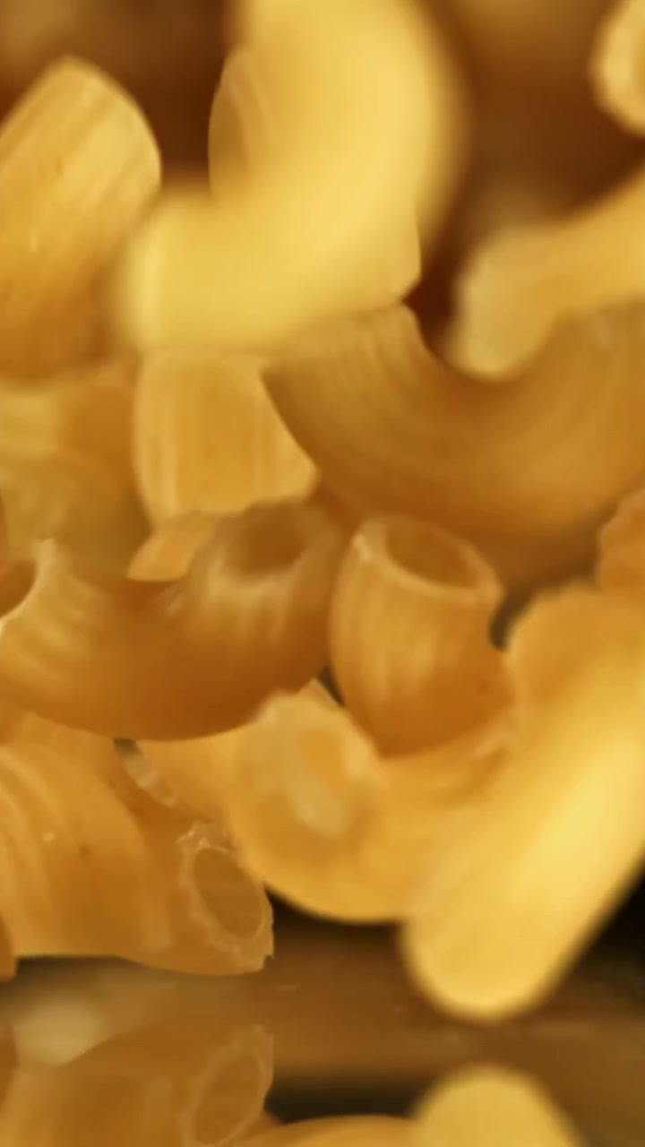 Primo piano di maccheroni crudi che cadono al rallentatore