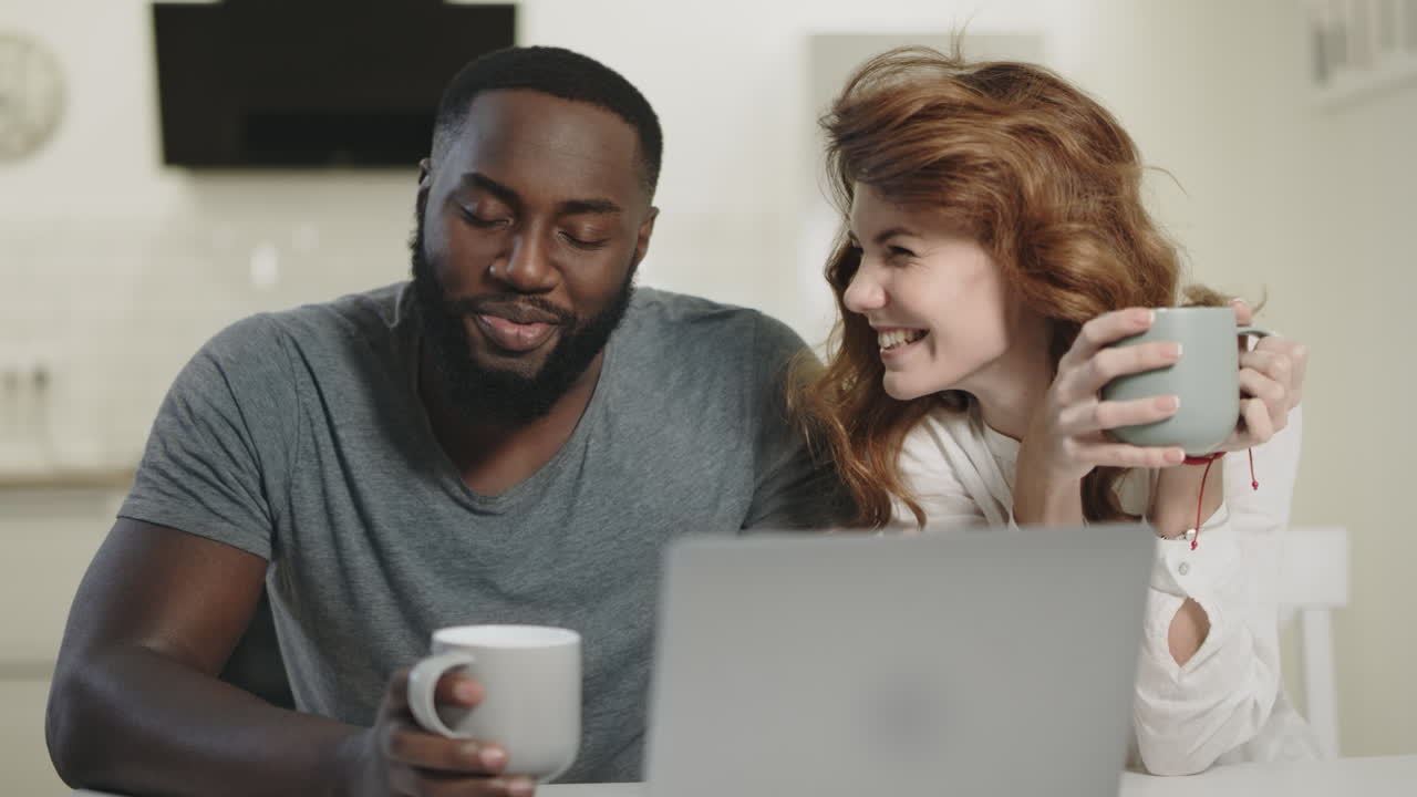 una pareja feliz conversando en la cocina.
