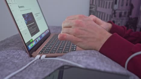 A-young-man-bounces-down-on-the-bed-and-makes-a-quick-web-search