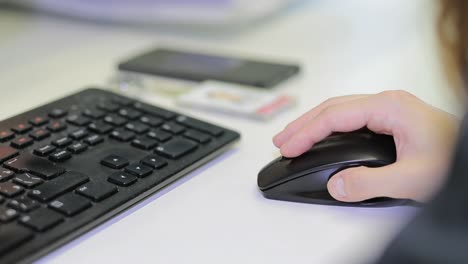 person using a computer mouse and keyboard