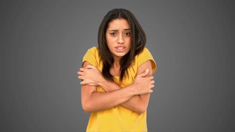 Woman-shivering-with-cold-on-grey-background