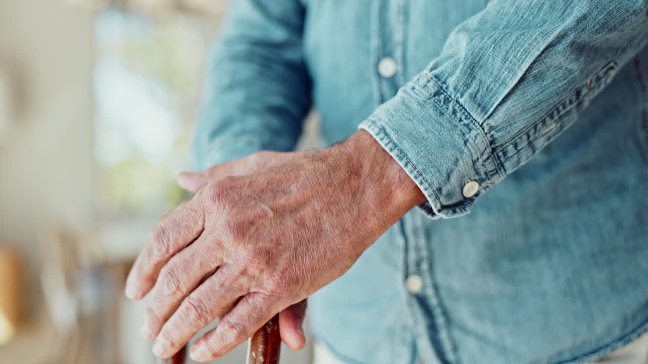 Close-up of a senior man's hands holding a walking cane