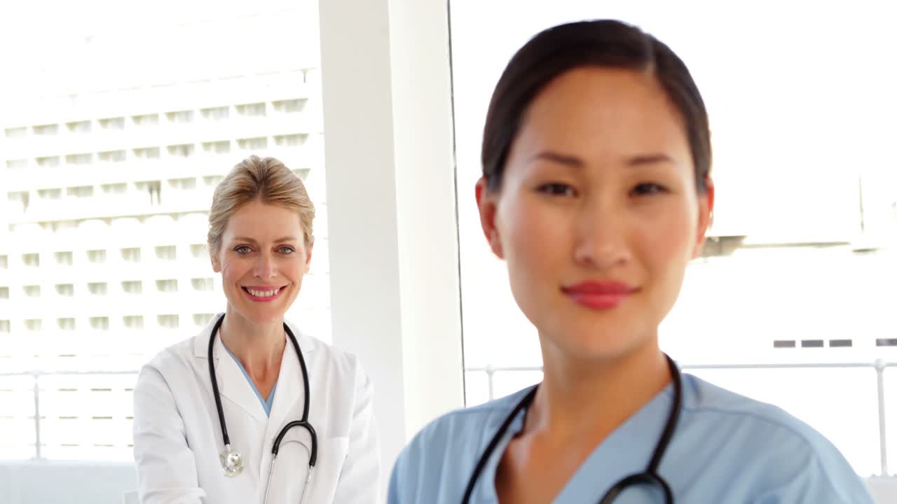 笑顔の外科医と彼女の後ろの医者