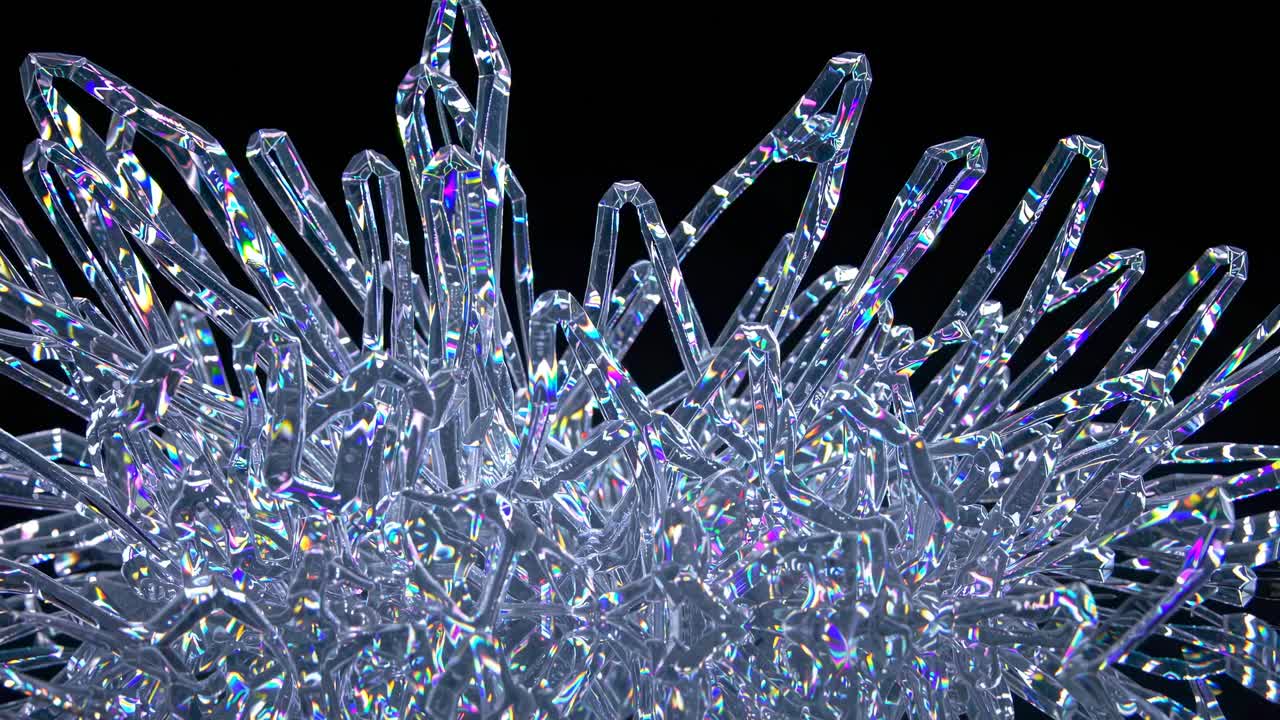Close-up video of iridescent crystal formations against a dark background, shot from a low angle