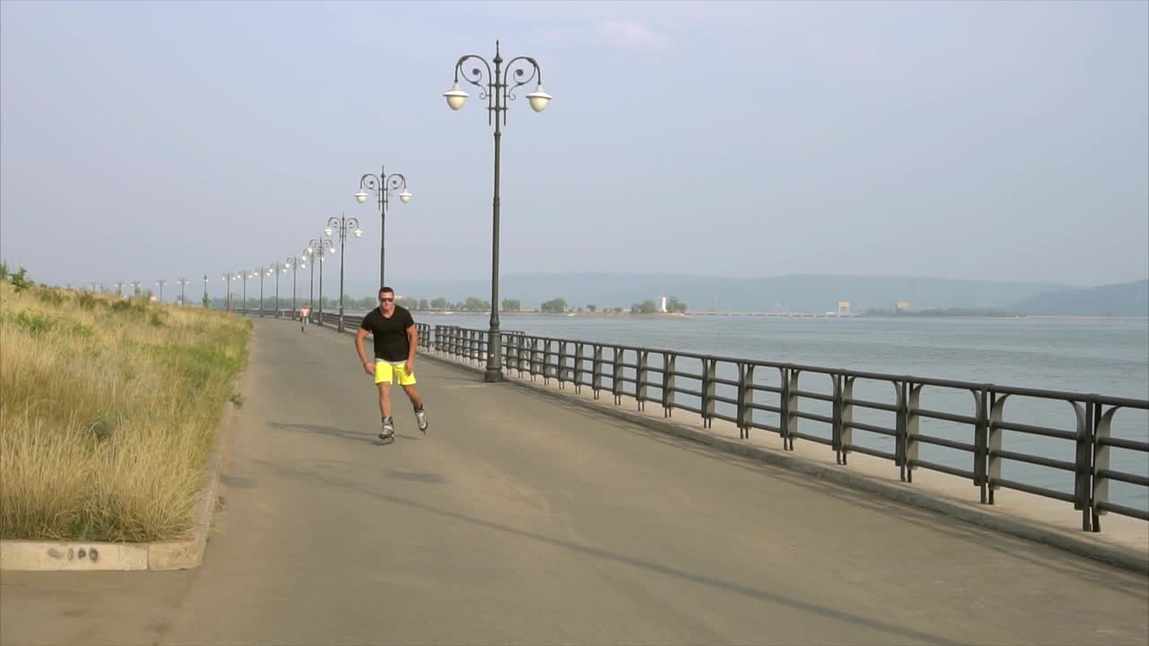 hombre patinando a lo largo de un paseo fluvial