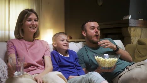 Family-sitting-on-the-sofa-and-watching-movie