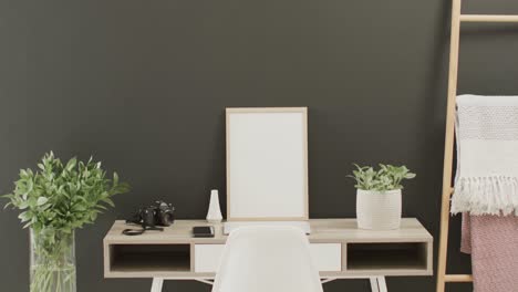 wooden frame with copy space on white background with plant on desk against grey wall