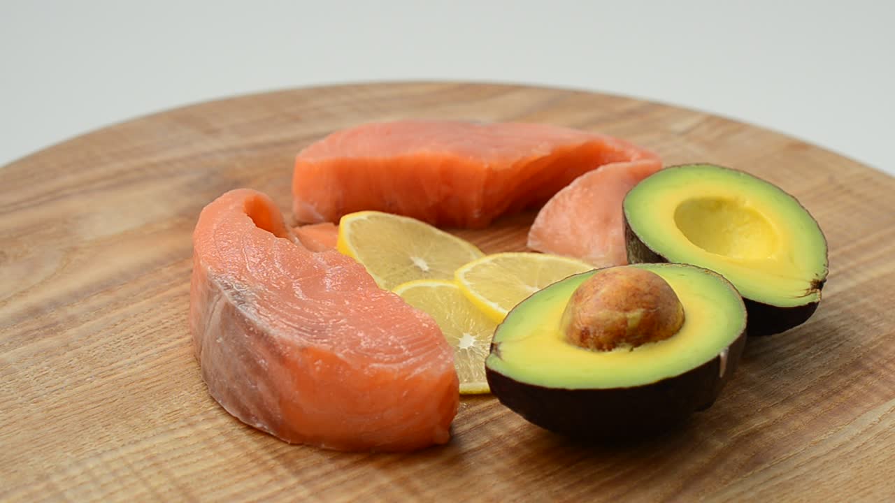 Salmone salato, avocado e limone su un tagliere da cucina. Gustosa natura morta, i prodotti combinati
