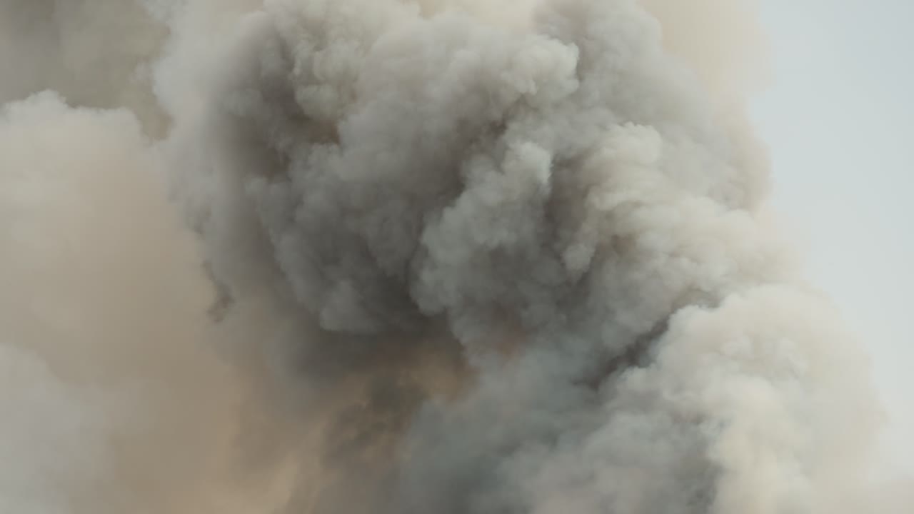 Black smoke clouds and flames rise into the sky.