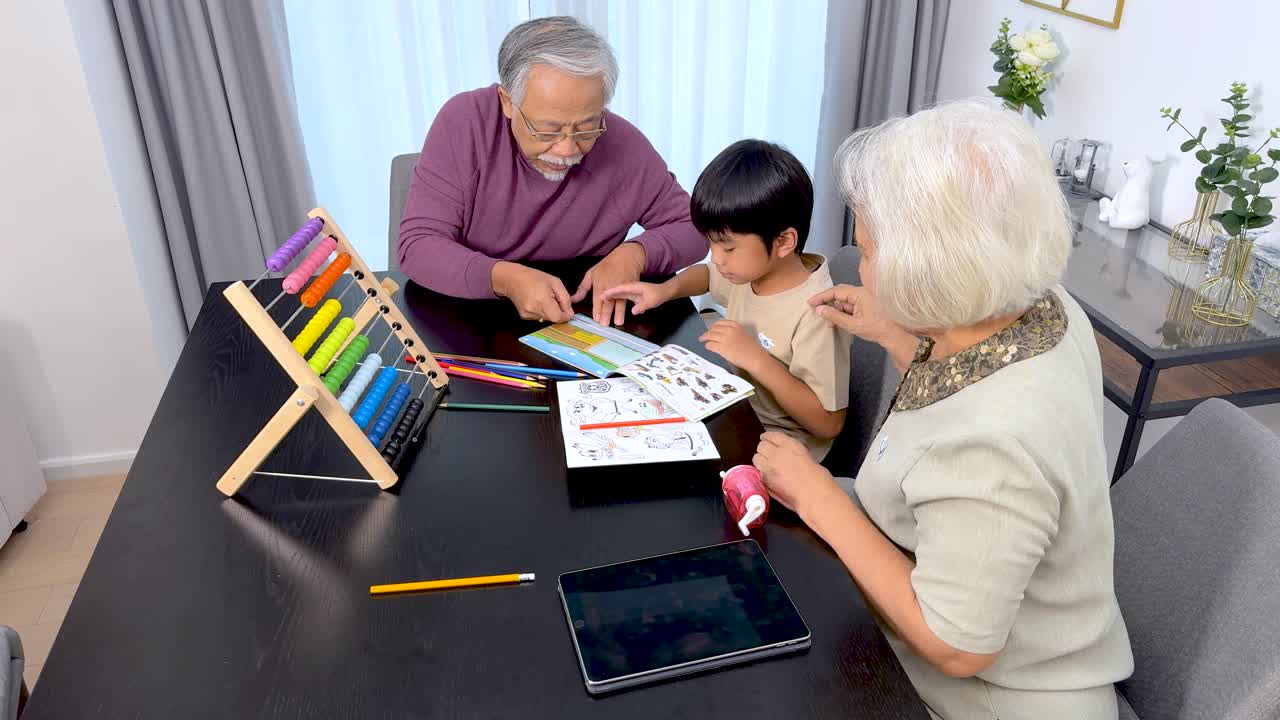 Elderly couple guides young boy with coloring activity in bright, modern home environment