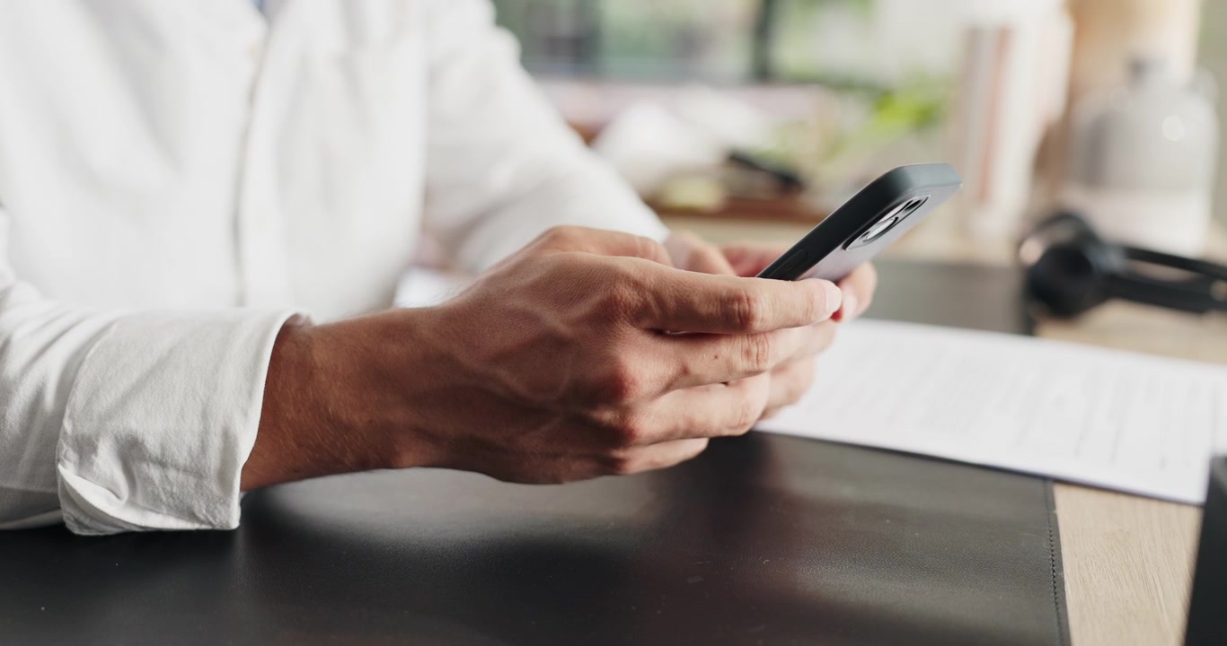 Man Using Smartphone at Desk in Office