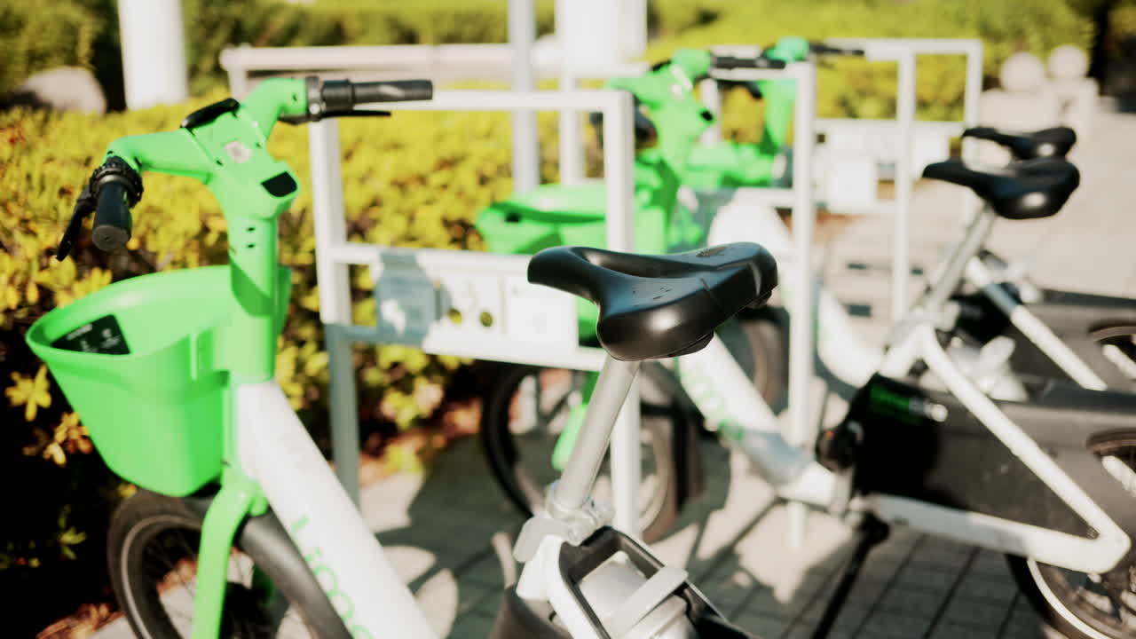 Cannes, France - October 13, 2025: Close up of green electric bicycles parked in a sunny city area