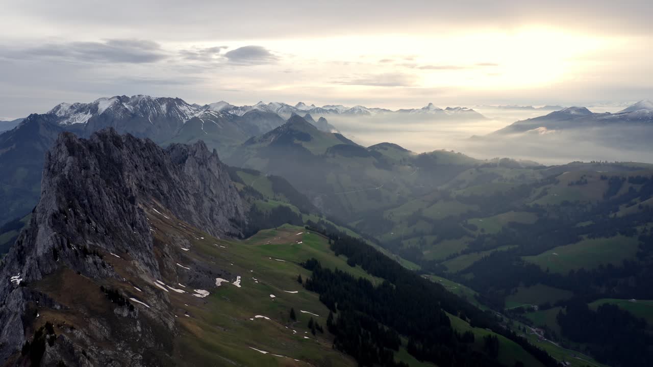 hermosa cresta entre las montañas por encima de un valle verde en un increíble amanecer nublado