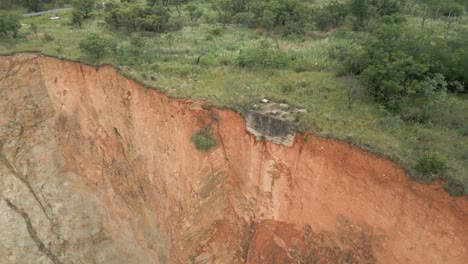 aerial descends to concrete foundation at edge of vertical rock cliff