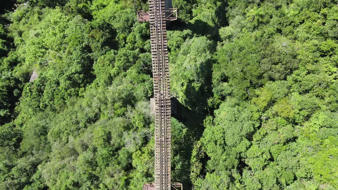 화창한 날 계곡을 건너기 시작한 고독한 등산객과 함께 계곡을 건너는 높은 철로 다리의 조감도