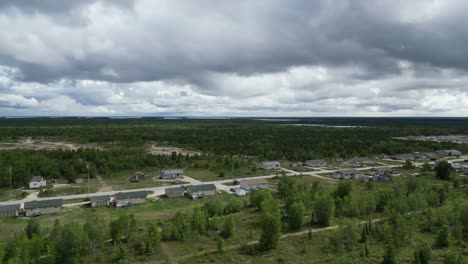 a moving aerial drone shot of a residential area in the easterville and chemawawin cree nation area during the summer months and overcast season