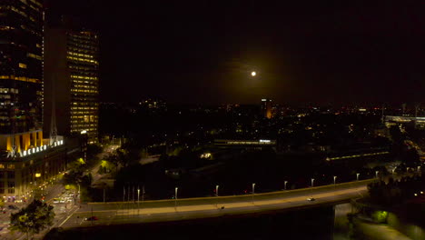 Luna-Llena-Colocada-Sobre-Tachuelas-De-Trenes-Urbanos-Con-El-Cruce-Arterial-Del-Puente-En-Primer-Plano