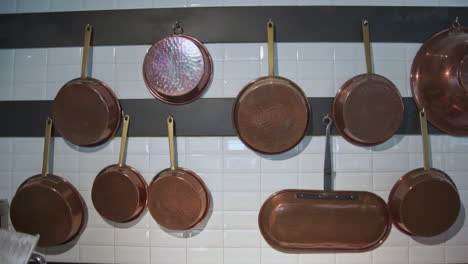 footage of copper pans hanging on a wall of an italian restaurant