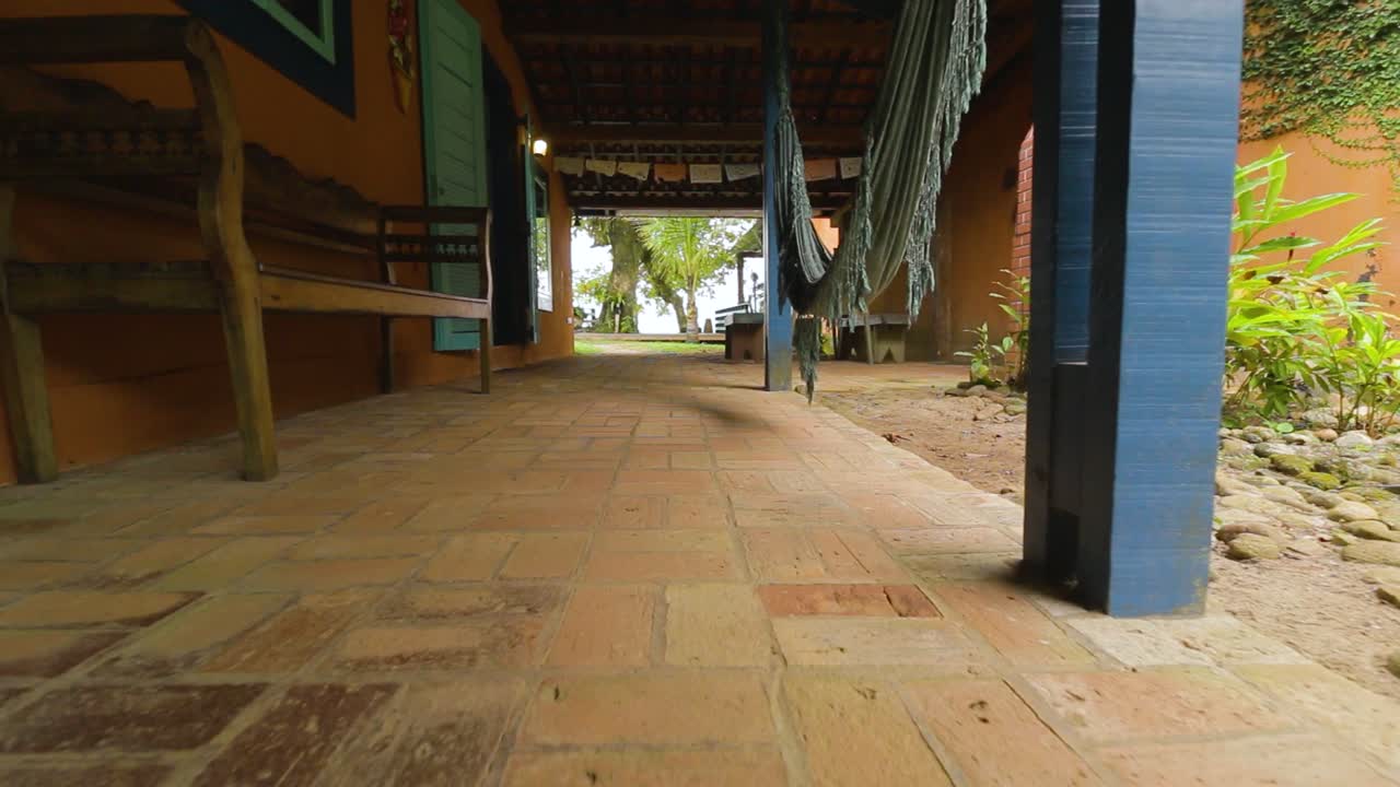 해먹과 소박한 땅이 있는 해변 집 외부의 모습