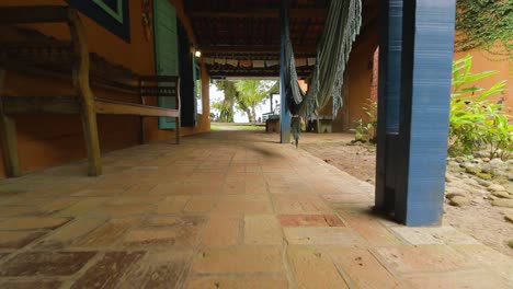 foto reveladora de una casa de playa afuera con hamacas y suelo rústico
