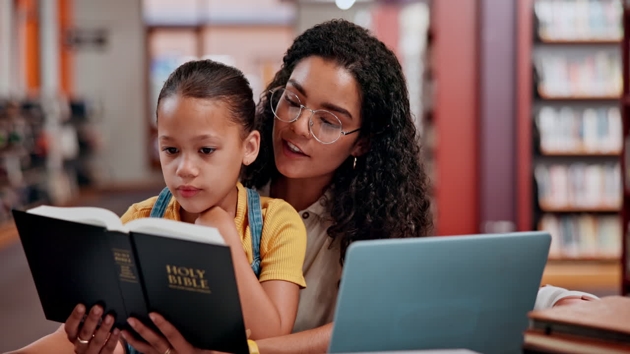 madre e hija leyendo la biblia en la biblioteca