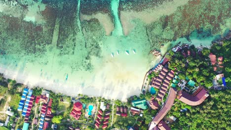 tropical atoll island surrounded by the fringing coral reef with preserved nature and luxury hotels and resorts