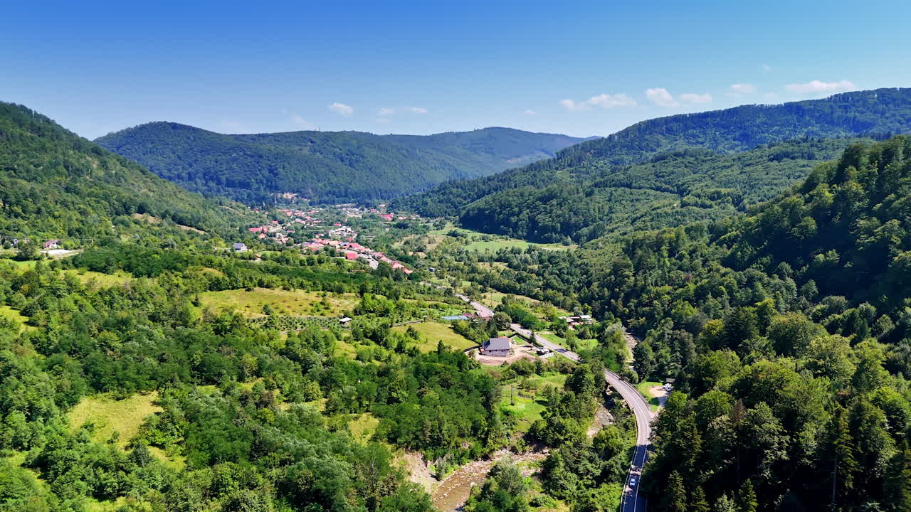 Vast landscape overlooking the Prahova Valley. The view extends far into the distance showing the town below