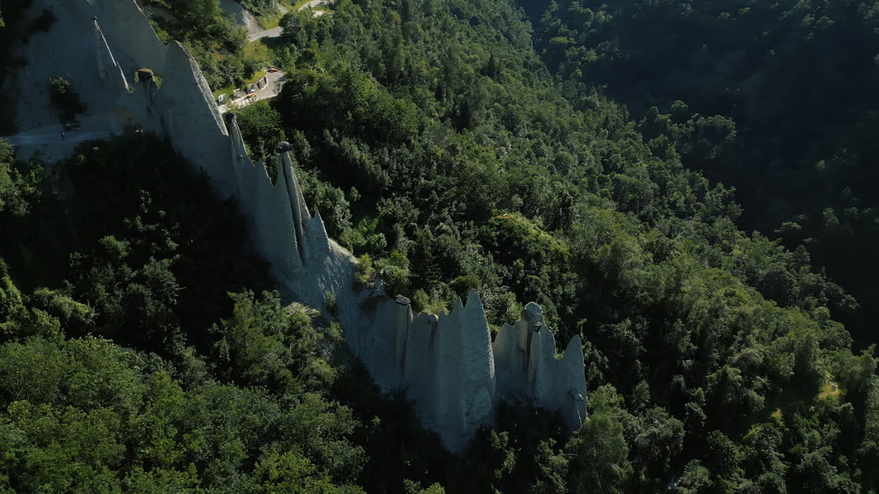 Orbit drone shot of fairy chimney rock formations during the day in Euseigne, canton of Valais, Switzerland
