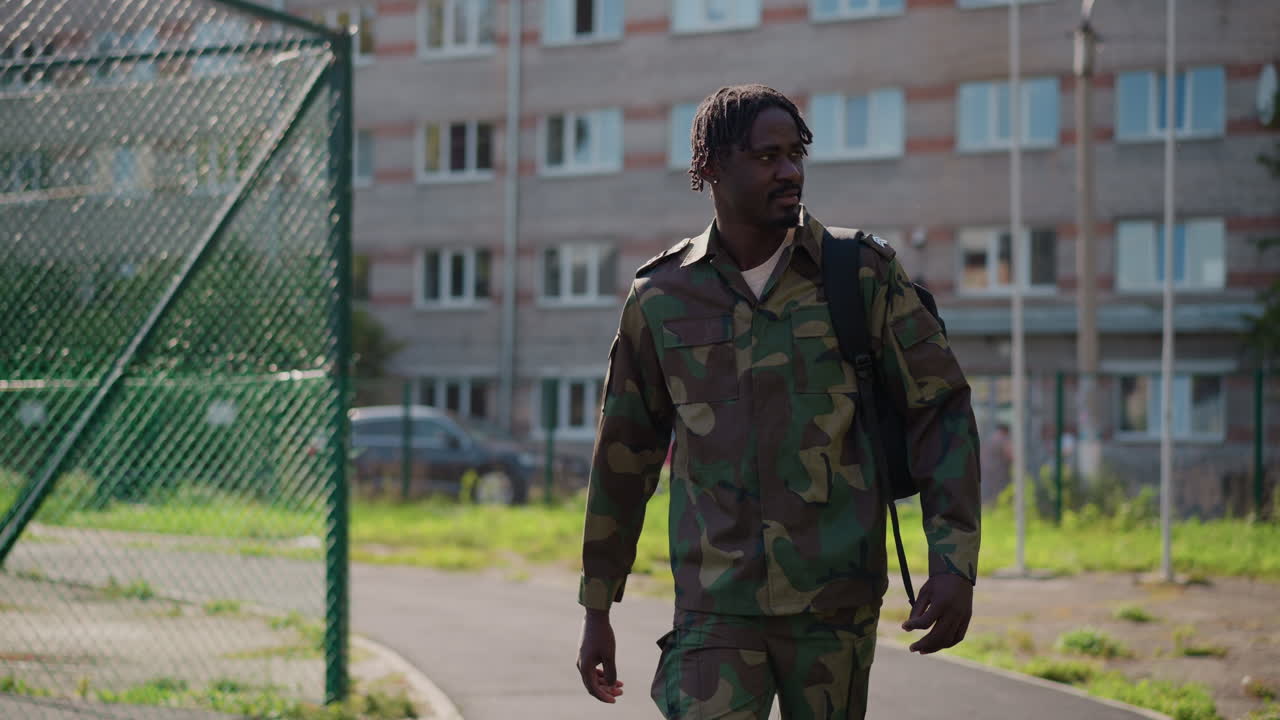 Wearied Marcher Pondering, Weary Infantryman Walking With Bowed Head Amidst Urban Scenery, Tired Military Personnel Passing Through City Streets With Thoughtful Expressions And Steady Steps