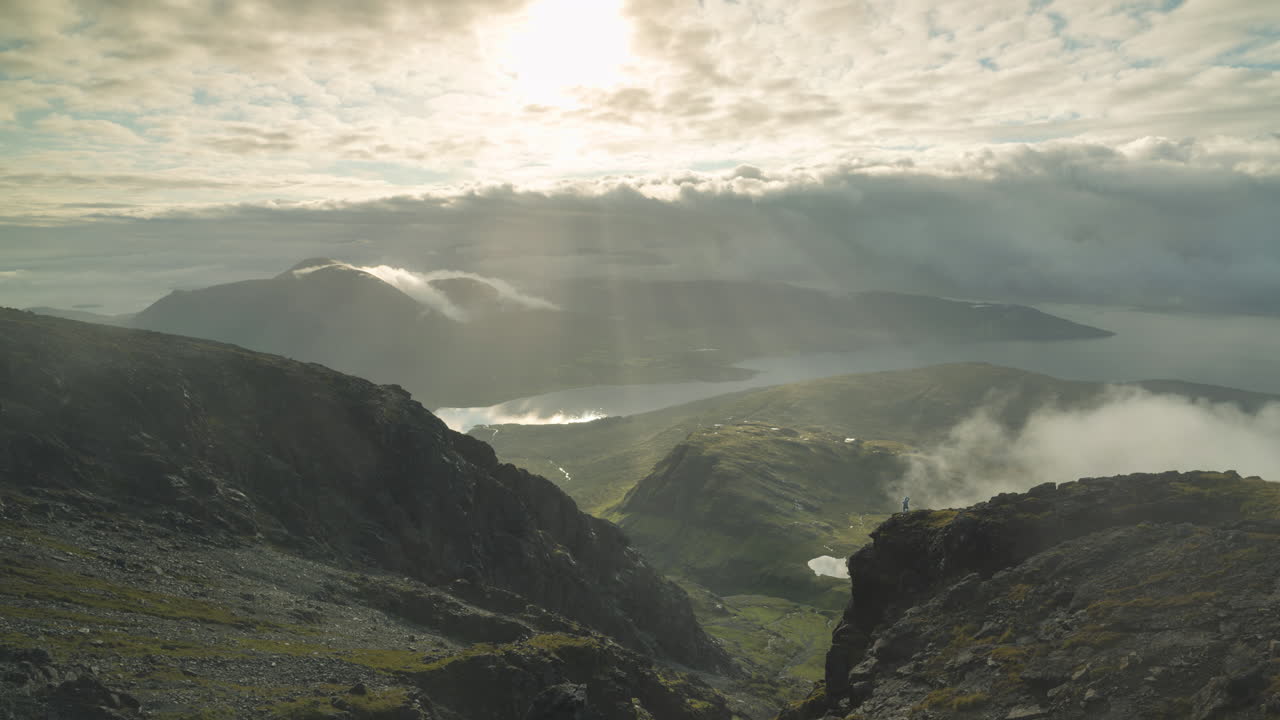 fotógrafo posando como silueta en las tierras altas escocesas contra las montañas y el valle como telón de fondo