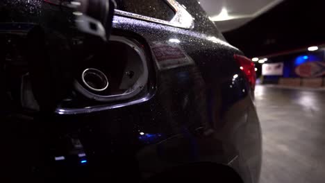 taking out nozzle from car after filling up fuel tank at gas station close up