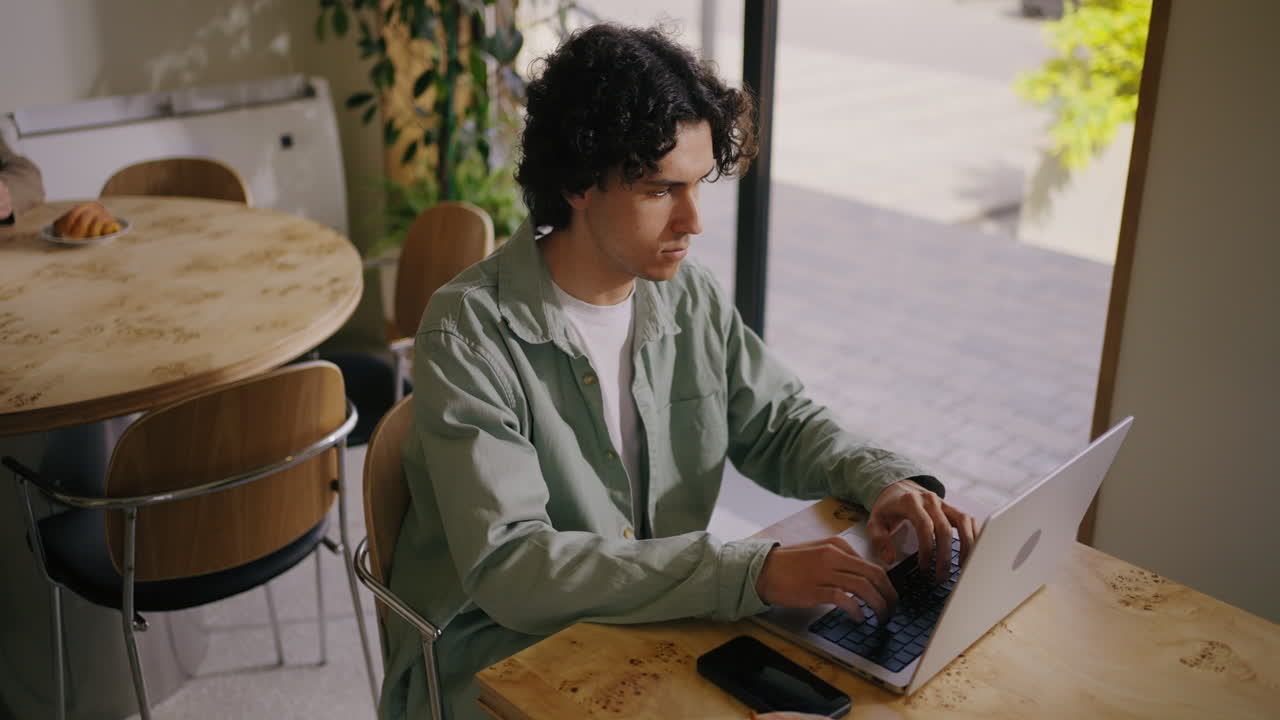 Man working on laptop at a coffee shop