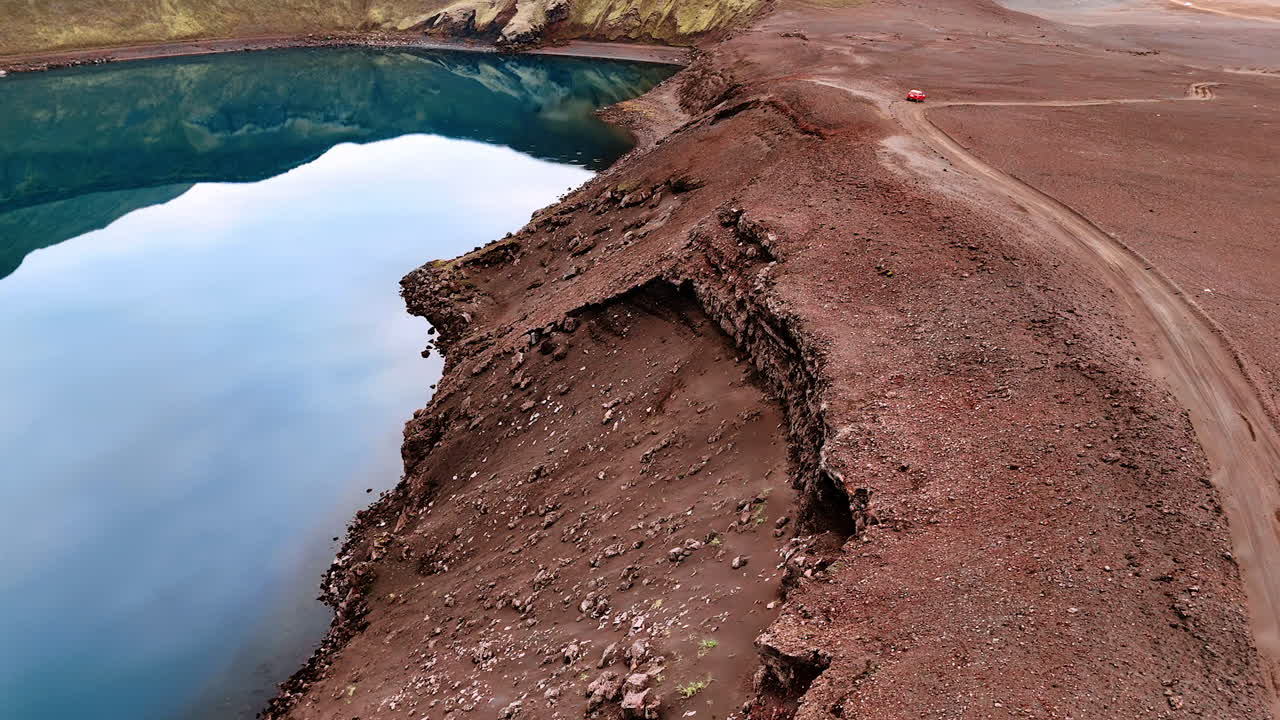 Blue sky reflecting in the water of the lake filling the crater of a sleeping volcano. Travel destination in Iceland. Aerial view.