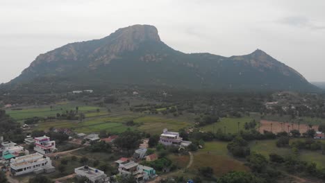sobrevuelo aéreo sobre un pueblo indio rodeado de bosques verdes y enormes montañas en medio del marco cubierto de verdes