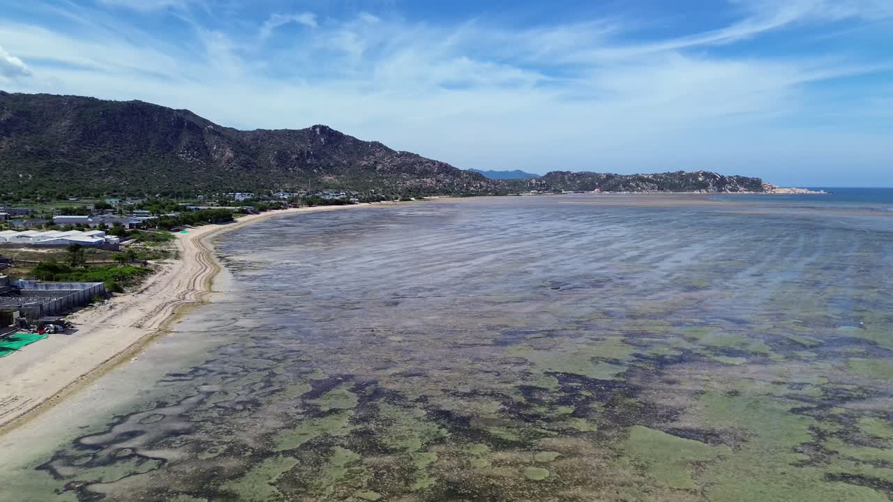 Aerial view of My Hoa Lagoon in Phan Rang, Vietnam, featuring a cinematic zoom in movement towards the scenic shoreline. My Hoa Vietnam, famous kitesurfing spot during low season.