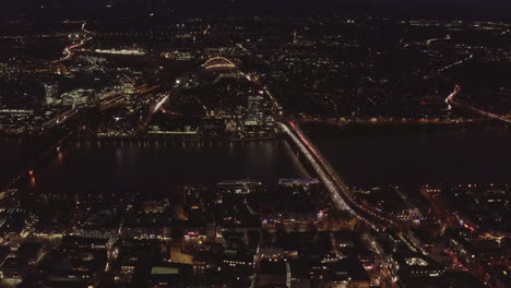 AERIAL:-Beautiful-Wide-Shot-over-Cologne-Germany-with-River-Rhine-and-Bridge-Car-traffic-and-City-lights