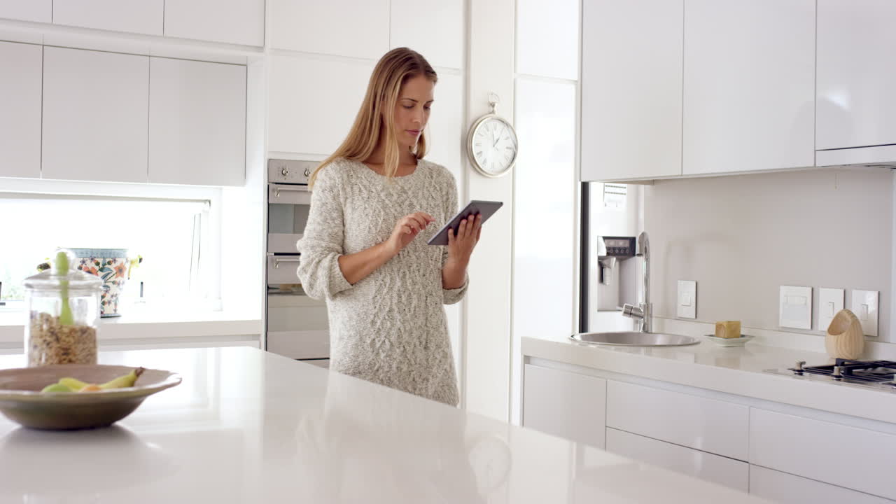 Una donna in una casa intelligente e connessa che usa l'Internet delle Cose per godersi uno stile di vita digitale.